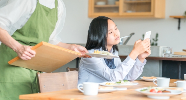 食事中にスマホを見て親の声を聞かない子どもの反抗的な態度。
