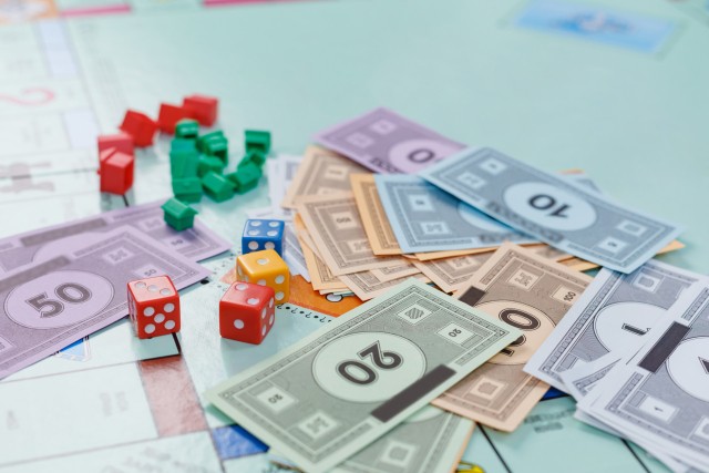 モノポリージュニアの紙幣やサイコロを使って子どもたちが楽しく遊んでいる様子のイメージ