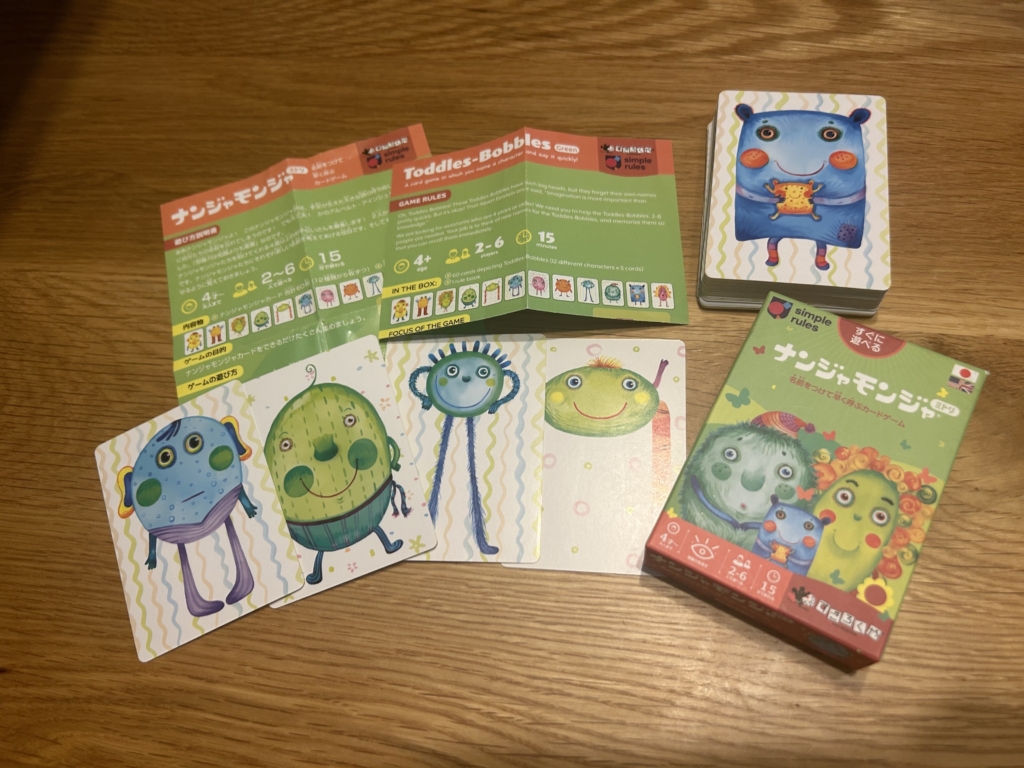 ナンジャモンジャのカードを広げてキャラクターの名前を呼びながら家族で遊んでいる様子のイラスト