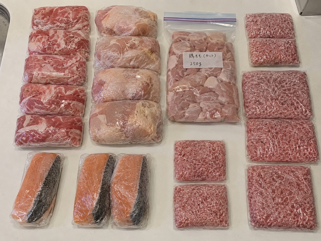 豚こま肉、鶏もも肉、カットした鶏もも肉、ひき肉（少量・多め）、生サケをラップやジップロックで小分け冷凍した冷凍ストックの写真